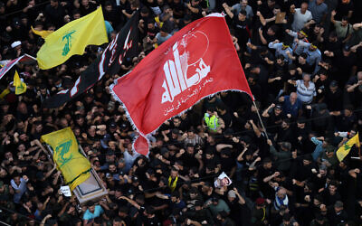 People wave Hezbollah flags as they accompany the casket of the Lebanese terror group's top military commander Fuad Shukr, during his funeral procession in Beirut's southern suburbs on August 1, 2024. (Ibrahim Amro/AFP)