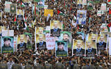 Yemenis wave flags and lift placards of Hezbollah senior commander Fuad Shukr, who was killed in an Israeli strike, and slain Hamas chief Ismail Haniyeh, during a rally in the Houthi-controlled capital Sanaa on August 2, 2024. (Abdallah Adel / AFP)