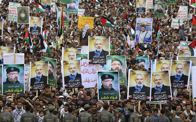 Yemenis wave flags and lift placards of Hezbollah senior commander Fuad Shukr, who was killed in an Israeli strike, and slain Hamas chief Ismail Haniyeh, during a rally in the Houthi-controlled capital Sanaa on August 2, 2024. (Abdallah Adel / AFP) Yemenis wave flags and lift placards of Hezbollah senior commander Fuad Shukr, who was killed in an Israeli strike, and slain Hamas chief Ismail Haniyeh, during a rally in the Houthi-controlled capital Sanaa on August 2, 2024. (Abdallah Adel / AFP)