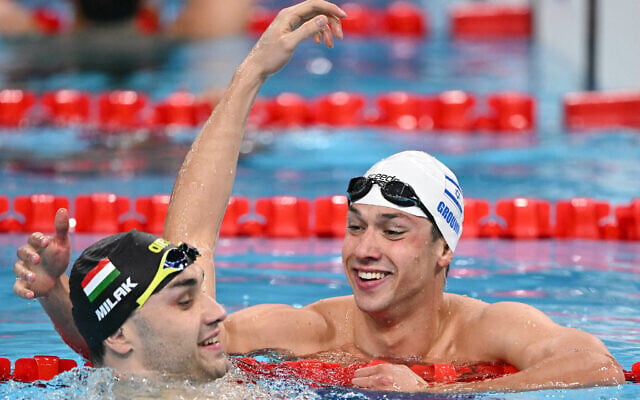 Hungary's Kristof Milak and Israel's Gal Cohen Groumi react after a heat of the men's 100m butterfly at the Paris 2024 Olympic Games at the Paris La Defense Arena in Nanterre, west of Paris, August 2, 2024. (Jonathan Nackstrand/AFP) Hungary's Kristof Milak and Israel's Gal Cohen Groumi react after a heat of the men's 100m butterfly at the Paris 2024 Olympic Games at the Paris La Defense Arena in Nanterre, west of Paris, August 2, 2024. (Jonathan Nackstrand/AFP)
