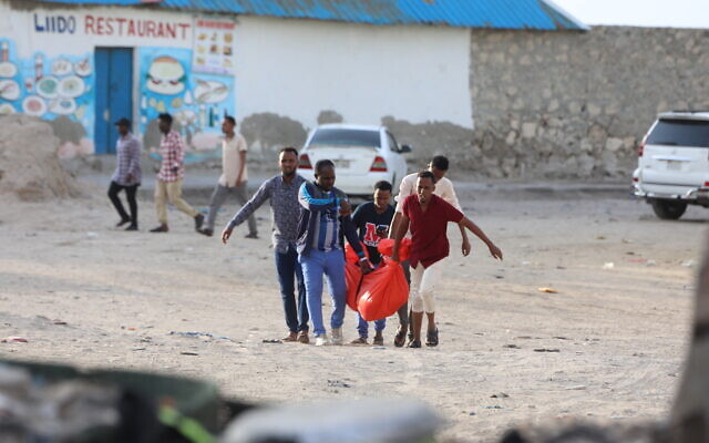 Relatives carry the body of a woman killed during an attack in Mogadishu on August 3, 2024. (Hassan Ali Elmi/AFP) Relatives carry the body of a woman killed during an attack in Mogadishu on August 3, 2024. (Hassan Ali Elmi/AFP)
