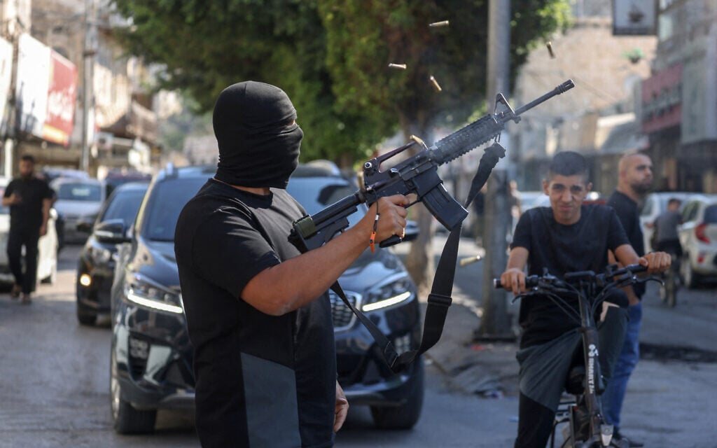 A gunman fires shots in the air during the funeral of five Palestinians killed in an Israeli strike in Jenin in the West Bank on August 6, 2024. (JAAFAR ASHTIYEH / AFP)