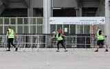 Security guards remove barriers in front of the Ernst Happel Stadium in Vienna, Austria, on August 8, 2024, after the three concerts of US mega-star Taylor Swift were canceled following the arrest of an Islamic State sympathizer in connection with an terror plot. (Alex Halada/AFP)