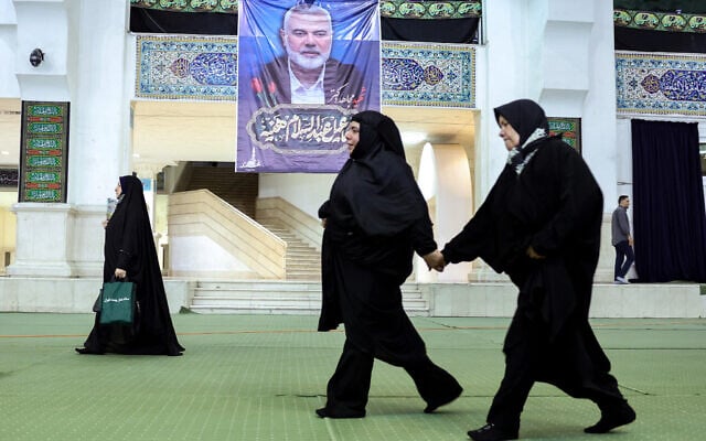 Iranians attend a memorial ceremony for slain leader of the Palestinian Hamas group Ismail Haniyeh (portrait top) at the Mosallah mosque in Tehran, on August 9, 2024. (AFP)