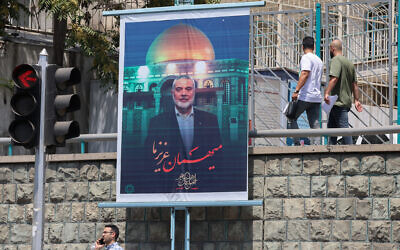 People walk past a poster of slain Palestinian Hamas terror group leader Ismail Haniyeh in Iran's capital Tehran on August 10, 2024. (Atta Kenare/AFP)