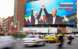 Vehicles drive past a huge billboard depicting Iranian President Masoud Pezeshkian (R) and slain Hamas leader Ismail Haniyeh at Tehran's Valiasr Square on August 12, 2024. (Atta Kenare/AFP)