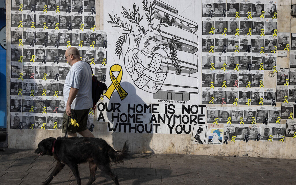 People walk past posters of Israelis held hostage in Gaza since October 7, on a street in Tel Aviv on August 13, 2024. (Oren ZIV / AFP)