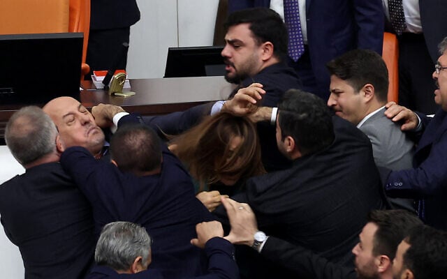 Turkish ruling and opposition lawmakers fight each other after a scuffle between former footballer Alpay Ozalan (unseen), a lawmaker from Erdogan's ruling AKP party and Turksih Workers Party (TIP) deputy Ahmet Sik (unseen) at Grand National Assembly of Turkey in Ankara on August 16, 2024. (Adem Altan/AFP) Turkish ruling and opposition lawmakers fight each other after a scuffle between former footballer Alpay Ozalan (unseen), a lawmaker from Erdogan's ruling AKP party and Turksih Workers Party (TIP) deputy Ahmet Sik (unseen) at Grand National Assembly of Turkey in Ankara on August 16, 2024. (Adem Altan/AFP)