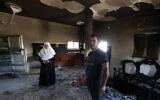 People stand inside their damaged home, a day after an attack by Jewish settlers on the village of Jit near Nablus in the West Bank that left a 23-year-old man dead and others with critical gunshot wounds, on August 16, 2024.(Jaafar ASHTIYEH / AFP)