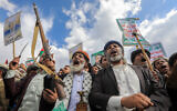 Armed Yemenis lift placards and flags during a rally in the Houthi-controlled capital Sanaa in solidarity with Palestinians amid the war in Gaza, August 16, 2024. (Abdallah Adel/AFP)