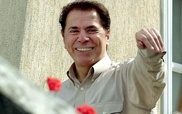 Brazilian television magnate and TV host Silvio Santos waves on 30 August, 2001, after being held hostage for seven hours in his home in Sao Paulo. (MAURICIO LIMA / AFP) Brazilian television magnate and TV host Silvio Santos waves on 30 August, 2001, after being held hostage for seven hours in his home in Sao Paulo. (MAURICIO LIMA / AFP)
