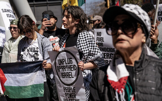 Anti-Israel activists hold placards and a Palestinian flag while protesting outside the offices of Glencore Coal in Sandton, Johannesburg on August 22, 2024. (Shiraaz Mohamed/AFP)
