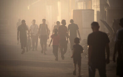 Palestinians find their way amid the dust and smoke after an Israeli strike on a building in Nuseirat in the central Gaza Strip on August 22, 2024. (Eyad Baba/AFP)