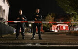 Police officers stand guard on August 24, 2024, near the cordoned-off area where at least three people were killed and several injured when a man attacked them with a knife late on August 23, 2024, in Solingen, western Germany, as the city celebrated its 650th anniversary. (Ina Fassbender/AFP)