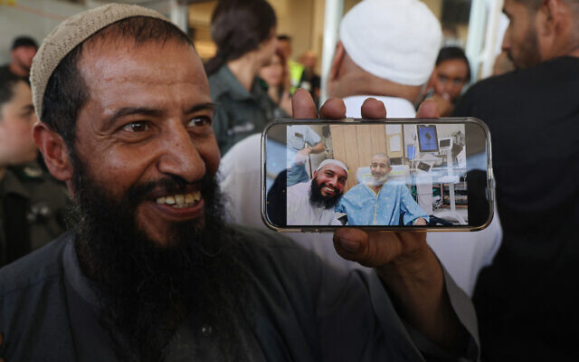 The brother of freed Israeli hostage Farhan al-Qadi shows a photo of him with another brother, after his arrival at the Soroka Medical Center in Beersheba on August 27, 2024. (Menahem KAHANA / AFP)