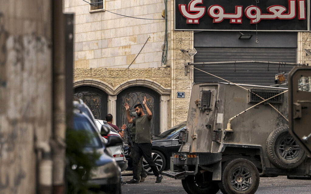 A Palestinian man raises his arms as he is stopped and searched by Israeli forces in the city of Hebron in the West Bank on August 31, 2024 after two attempted car bombings  (Photo by HAZEM BADER / AFP)