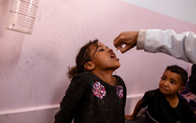 A nurse administers Polio vaccine drops to a young Palestinian patient at the Nasser hospital in Khan Yunis in the southern Gaza Strip on August 31, 2024. (Jihad Al-Sharafi/AFP)
