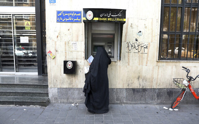 File: A woman uses an ATM machine at a branch of the Bank Melli Iran, at the Grand Bazaar of Tehran, Iran, June 10, 2020. (AP Photo/Vahid Salemi)