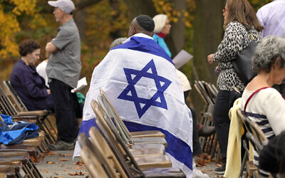 Illustrative: A man draped in an Israeli flag waits for the start of a commemoration ceremony, on October 27, 2023, in in the Squirrel Hill neighborhood of Pittsburgh to remember the 11 worshippers killed by a gunman at the Tree of Life synagogue five years earlier. (AP Photo/Gene J. Puskar)