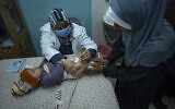 A Palestinian child receives a pentavalent shot, which protects against five diseases, in Gaza's southernmost city of Rafah, January 2, 2024, after the vaccines were delivered to the Strip in an international aid shipment. (AP Photo/Fatima Shbair)