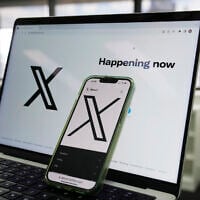 The opening page of X is displayed on a computer and phone, October 16, 2023, in Sydney. (AP Photo/Rick Rycroft)