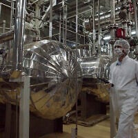 In this illustrative image, an Iranian security official in protective clothing walks through a nuclear facility just outside the Iranian city of Isfahan, March 30, 2005. (Vahid Salemi/AP)