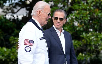 US President Joe Biden, left, wearing a Team USA jacket and walking with his son Hunter Biden, heads toward Marine One on the South Lawn of the White House in Washington, July 26, 2024. (AP Photo/Susan Walsh)