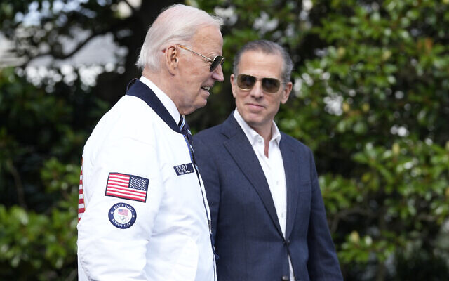 US President Joe Biden, left, wearing a Team USA jacket and walking with his son Hunter Biden, heads toward Marine One on the South Lawn of the White House in Washington, July 26, 2024. (AP Photo/Susan Walsh)