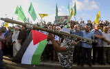 A supporter of Hezbollah and Hamas holds a mock rocket at a protest to condemn the killing of the Hamas terror group chief Ismail Haniyeh, in the southern port city of Sidon, Lebanon, July 31, 2024. (AP Photo/Mohammed Zaatari)