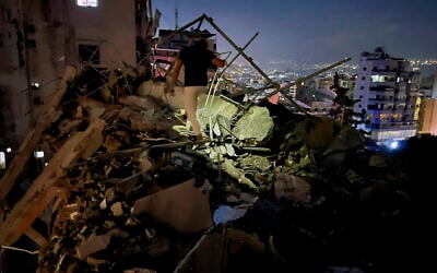 A man inspects the ruins of a building hit by an airstrike targeting Hezbollah military leader Fuad Shukr in the southern suburbs of Beirut, Lebanon, July 30, 2024. (AP/Hussein Malla)