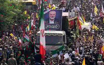 Iranians follow a truck carrying the coffins of Hamas terror group leader Ismail Haniyeh and his bodyguard, who were killed in an assassination, during their funeral ceremony in Tehran, Iran, August 1, 2024. (AP Photo/ Vahid Salemi)