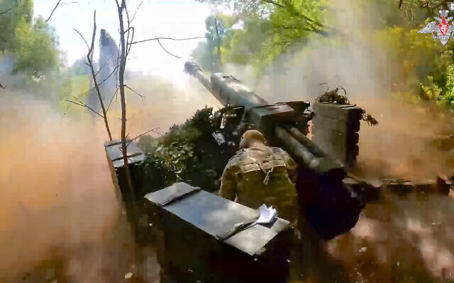 In this photo taken from video released by the Russian Defense Ministry on Wednesday, Aug. 7, 2024, a Russian soldier fires from D-30 howitzer towards Ukrainian positions in an undisclosed location in Ukraine. (Russian Defense Ministry Press Service via AP)