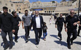 National Security Minister Itamar Ben Gvir, center, flanked by his security detail, approaches the entrance to the Temple Mount in the Old City of Jerusalem, August 13, 2024. (AP Photo/Ohad Zwigenberg)