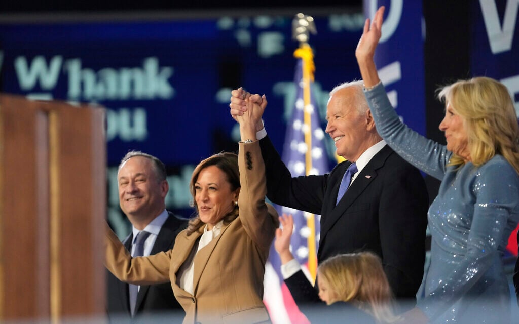 Democratic US presidential nominee Vice President Kamala Harris, center left, clasps hands with US President Joe Biden, center right, as they are flanked by their spouses at the Democratic National Convention in Chicago, Illinois, August 19, 2024. (AP Photo/Paul Sancya)