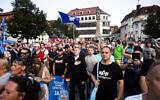 Supporters of the far-right Alternative for Germany party, or AfD, sing the national anthem as they attend an election campaign rally of the party for upcoming state elections in Suhl, Germany, August 13, 2024. (AP Photo/Markus Schreiber)