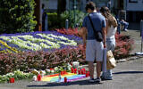 People place flowers near the scene of a knife attack in Solingen city center, Germany, August 24, 2024. (Henning Kaiser/ dpa via AP)