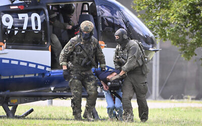 Issa Al Hasan, the alleged perpetrator of a knife attack that killed three people in Solingen, is escorted from a helicopter in Karlsruhe, Germany, August 25, 2024. (Uli Deck/dpa via AP)
