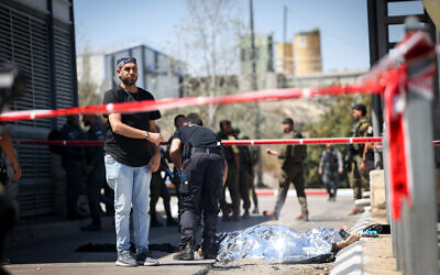 Police and medical personnel at the scene of a stabbing attack at the Tunnels Checkpoint in the West Bank, south of Jerusalem, on August 6, 2024. (Yonatan Sindel/FLASH90)