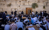 Jewish men pray during Tisha B'Av, at the Western Wall in the Old City of Jerusalem, August 13, 2024. (Chaim Goldberg/Flash90)