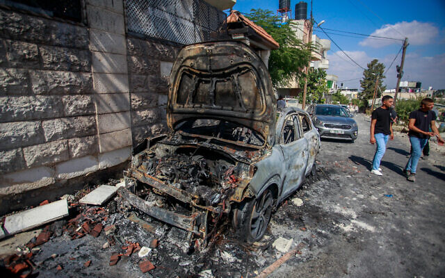 Palestinians inspect damage in the West Bank village of Jit a day after extremist settlers attacked the town, August 16, 2024. (Nasser Ishtayeh/Flash90)