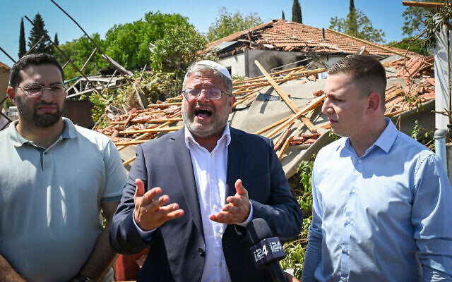 National Security Minister Itamar Ben Gvir (center) at the scene of a direct hit from a missile attack in Katzrin, Golan Heights, with the city's Mayor Yehuda Dua (left) and Golan Heights Regional Council head Ori Kalner on August 21, 2024. (Michael Giladi/Flash90) National Security Minister Itamar Ben Gvir (center) at the scene of a direct hit from a missile attack in Katzrin, Golan Heights, with the city's Mayor Yehuda Dua (left) and Golan Heights Regional Council head Ori Kalner on August 21, 2024. (Michael Giladi/Flash90)