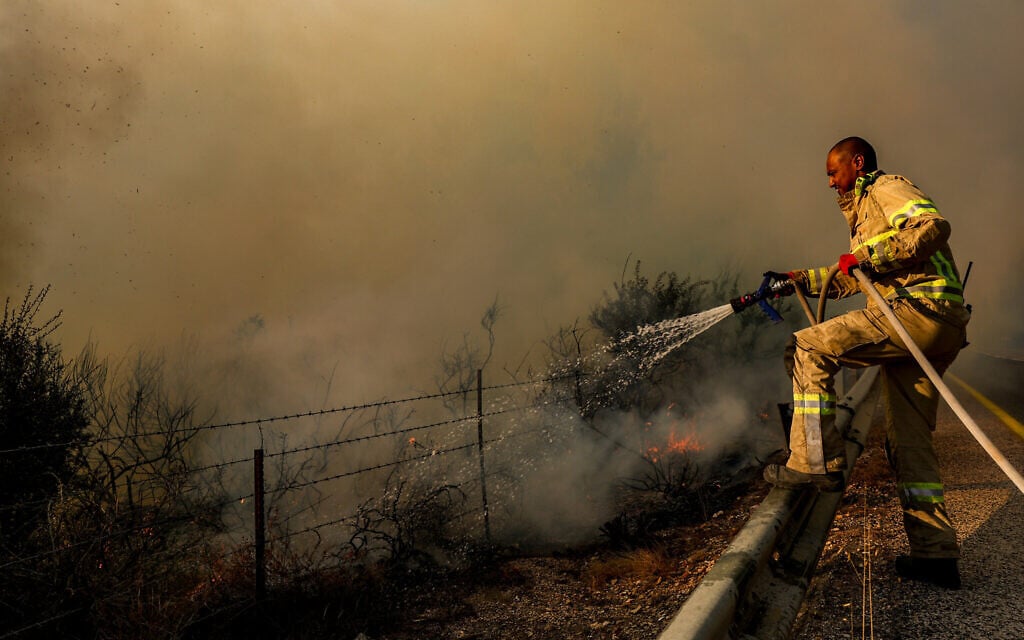 Firefighters battle a blaze sparked by rockets fired from Lebanon, near Meron, northern Israel, August 23, 2024. (David Cohen/Flash90)