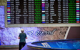 A man looks at the board displaying multiple delayed and cancelled flights at Ben Gurion International airport on August 25, 2024. (Avshalom Sassoni/Flash90)