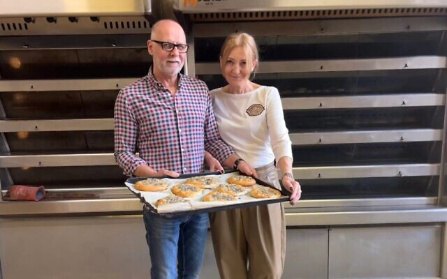 Katarzyna and Artur Goławski, co-managers of the Kuzmiuk Bakery, hold their signature cebularz, once called pletzel by Lublin's Yiddish-speaking Jews. (Shira Li Bartov/ JTA)