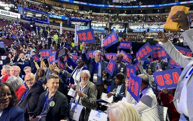 Democratic US delegates celebrate on the floor of the United Center after voting to adopt their party’s platform at the Democratic National Convention on August 19, 2024. (Jacob Magid/Times of Israel)