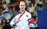 Israeli swimmer Mark Malyar poses for a photo with his bronze medal in the men's 100m backstroke at the Paris Paralympics on August 31, 2024. (Lilach Weiss Rosenberg)