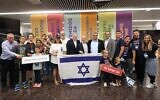 New immigrants pose with Aliyah and Integration Minister Ofir Sofer, ministry director-general Adv. Avichai Kahana, Jewish Agency for Israel deputy director-general Shay Felber, Nefesh B'Nefesh co-founder and chairman Tony Gelbart and Nefesh B’Nefesh co-founder and executive director of Rabbi Yehoshua Fass upon their arrival to Israel, Ben Gurion International Airport, Tel Aviv, August 22, 2024. (Nefesh B'Nefesh/Chen Galili)