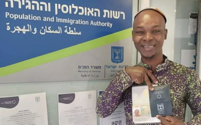 Yosef Kibita poses with his new Israeli passport. (Courtesy Masorti Movement in Israel)