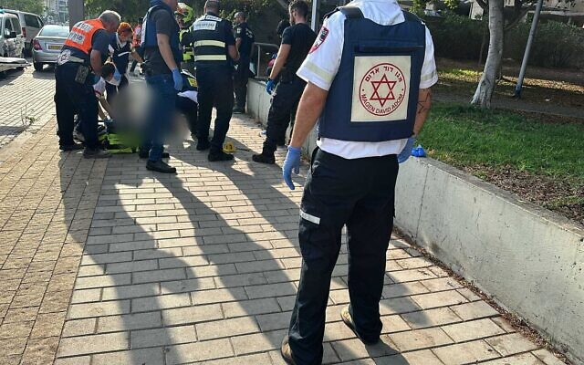 Medics treat people injured in a suspected terror stabbing in the central city of Holon, August 4, 2024. (Magen David Adom) Medics treat people injured in a suspected terror stabbing in the central city of Holon, August 4, 2024. (Magen David Adom)