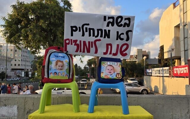A protest calling for a hostage in Nes Ziona, with backpacks featuring the faces of hostages Ariel and Kfir Bibas and the sign, 'No one starts the school year in captivity,' August 31, 2024. (Ohad Shahar/Pro-Democracy Protest Movement) A protest calling for a hostage in Nes Ziona, with backpacks featuring the faces of hostages Ariel and Kfir Bibas and the sign, 'No one starts the school year in captivity,' August 31, 2024. (Ohad Shahar/Pro-Democracy Protest Movement)